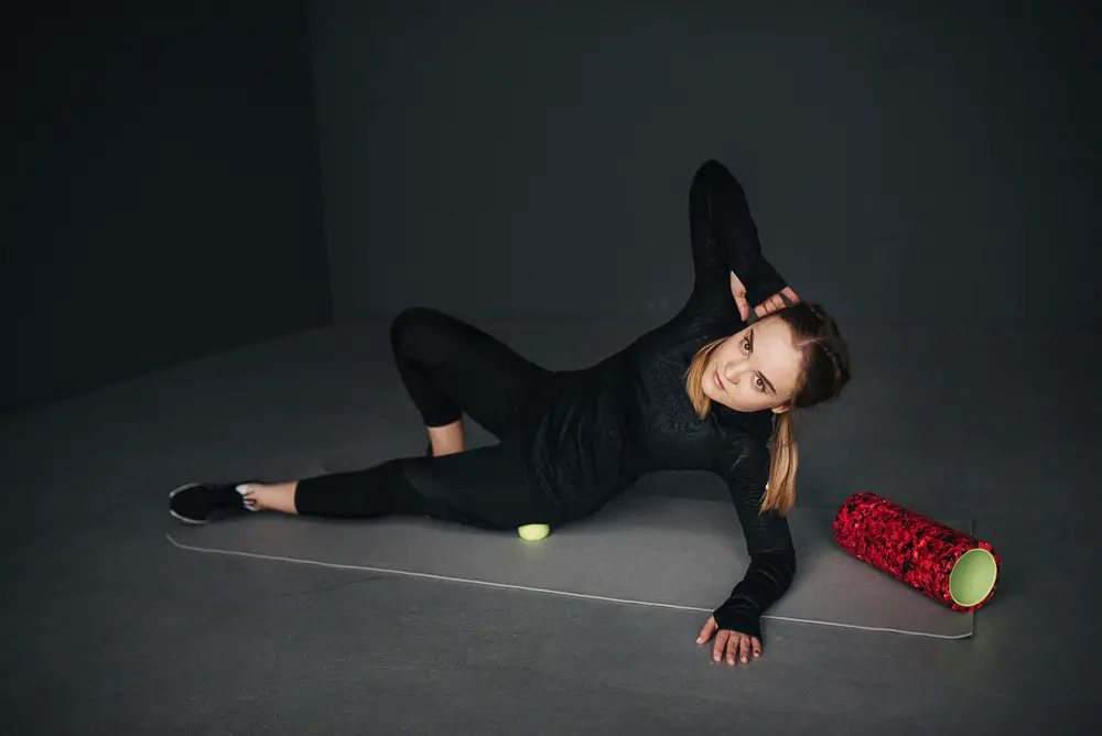 female sportswoman uses a tennis ball for relaxation