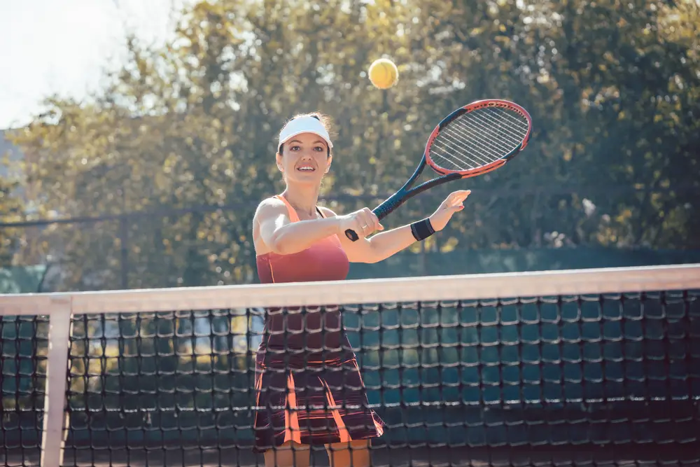 Woman in red sport dress playing tennis
