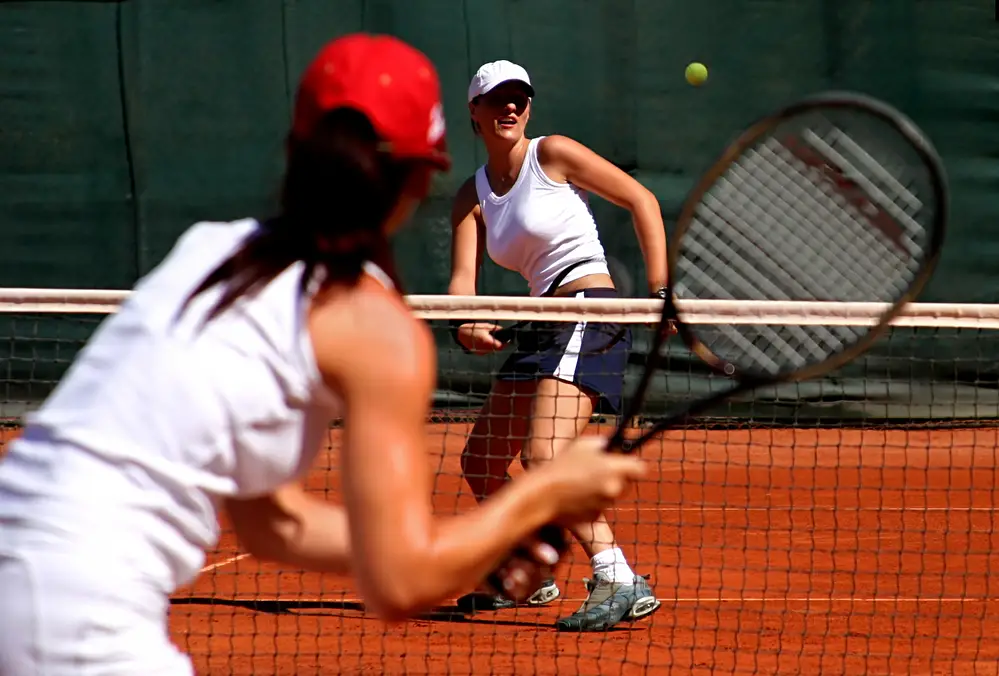 two girls play tennis